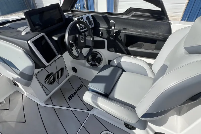 Slide: The Image of 2021 Malibu Wakesetter 25 LSV boat interior with modern dashboard and seating. - 10