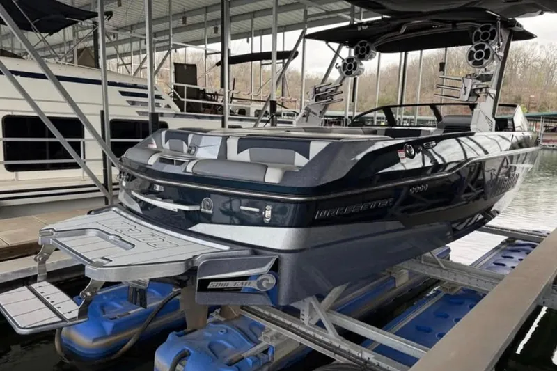 Slide: The Image of 2021 Malibu Wakesetter 25 LSV boat docked in a marina. - 14