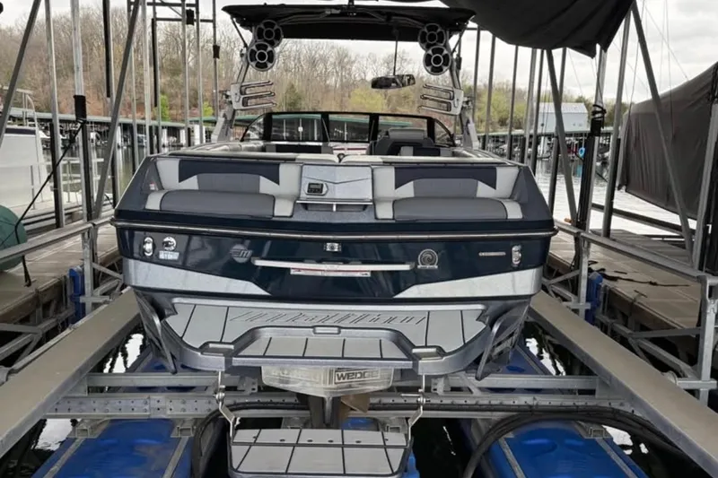 Slide: The Image of 2021 Malibu Wakesetter 25 LSV boat docked in a marina, rear view. - 15