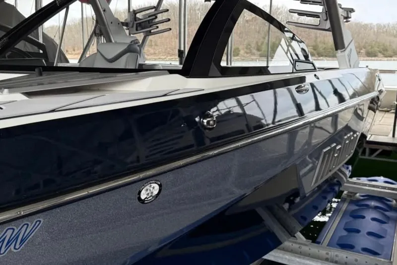 Slide: The Image of 2021 Malibu Wakesetter 25 LSV boat in dock, sleek design, blue exterior. - 18