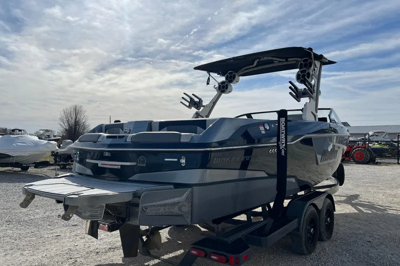 Slide: The Image of 2021 Malibu Wakesetter 25 LSV boat on trailer under cloudy sky. - 5