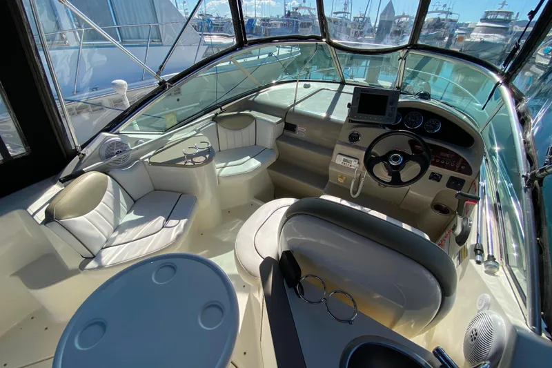 Slide: The Image of 2006 Sea Ray 240 Sundancer boat interior with helm, seating, and navigation equipment. - 14