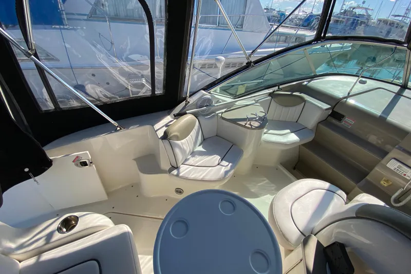 Slide: The Image of 2006 Sea Ray 240 Sundancer boat interior with seating and table, docked at marina. - 15