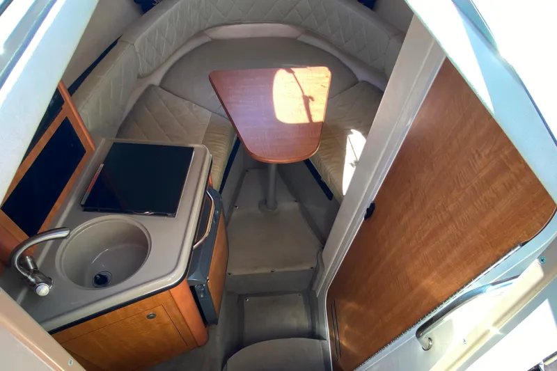 Slide: The Image of Interior of 2006 Sea Ray 240 Sundancer boat with kitchenette and seating area. - 16