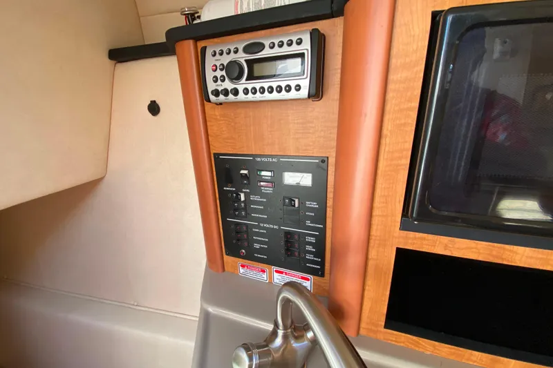 Slide: The Image of 2006 Sea Ray 240 Sundancer cabin control panel with stereo and electrical switches. - 20