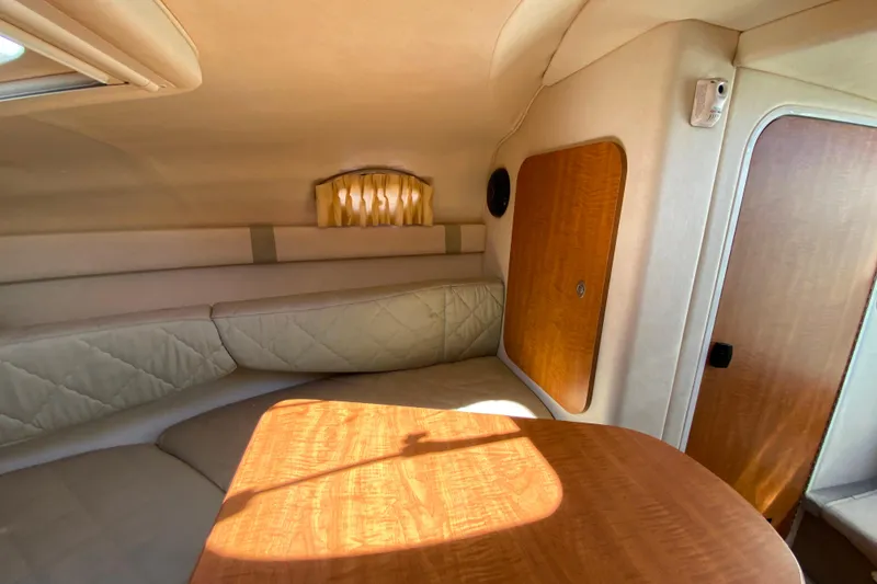 Slide: The Image of Interior cabin of 2006 Sea Ray 240 Sundancer with wood accents and seating area. - 24