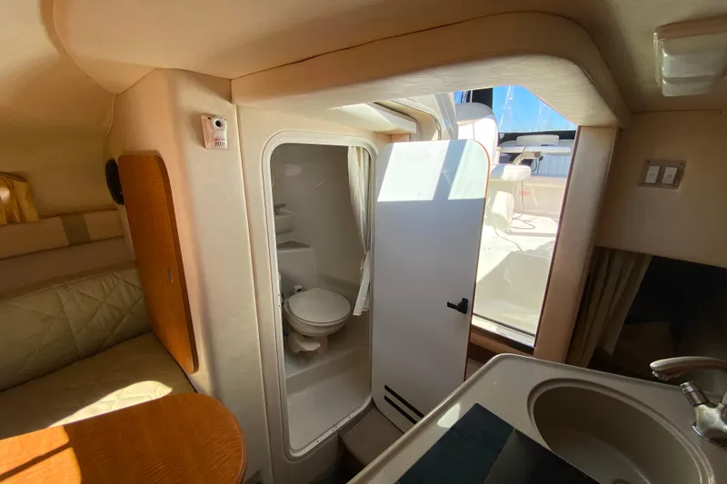 Slide: The Image of Interior of 2006 Sea Ray 240 Sundancer showing compact bathroom and seating area. - 26