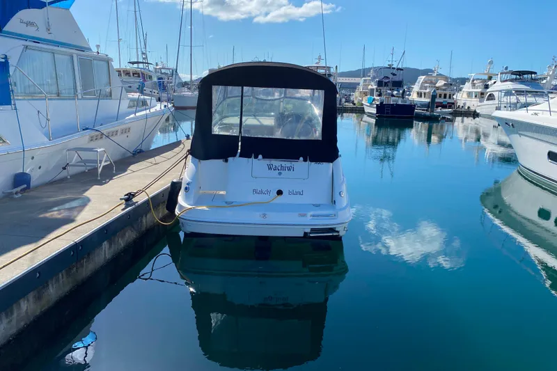 Slide: The Image of 2006 Sea Ray 240 Sundancer docked in a marina, surrounded by other boats. - 29