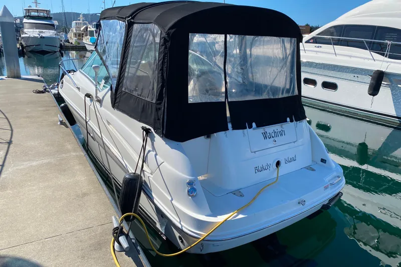 Slide: The Image of 2006 Sea Ray 240 Sundancer docked at marina with black canopy. - 30