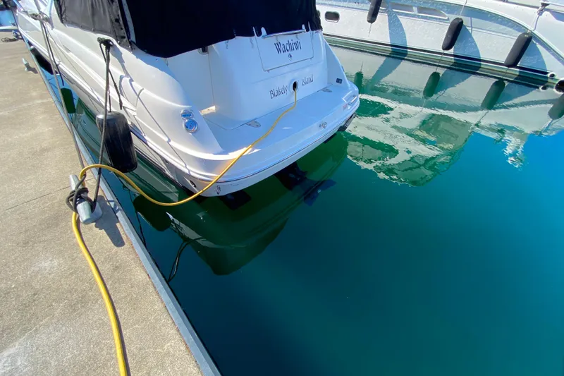 Slide: The Image of 2006 Sea Ray 240 Sundancer docked, reflecting on calm blue water. - 34