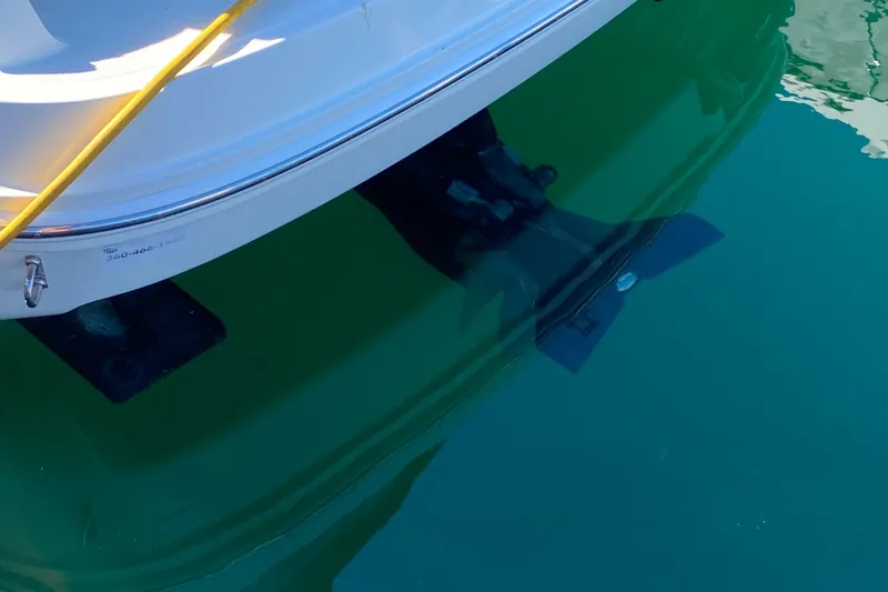 Slide: The Image of 2006 Sea Ray 240 Sundancer boat stern in clear water, showing propeller and hull. - 35
