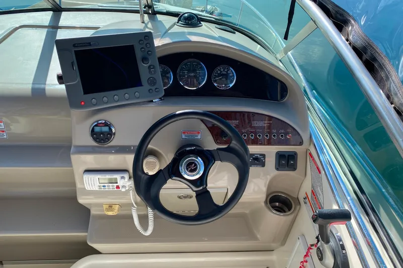 Slide: The Image of Helm of 2006 Sea Ray 240 Sundancer with steering wheel and navigation controls. - 4