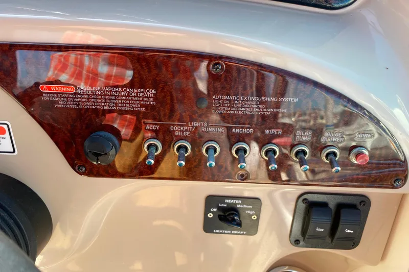 Slide: The Image of Control panel of a 2006 Sea Ray 240 Sundancer boat with various switches and warnings. - 9