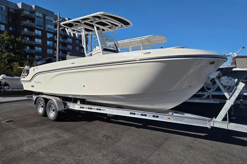 The Image of 2023 Trophy T24 CC boat on trailer, parked outdoors under clear blue sky. - 1