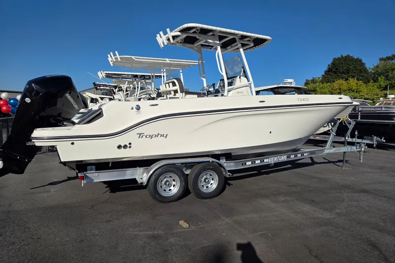 Slide: The Image of 2023 Trophy T24 CC boat on trailer, displayed outdoors under clear blue sky. - 3