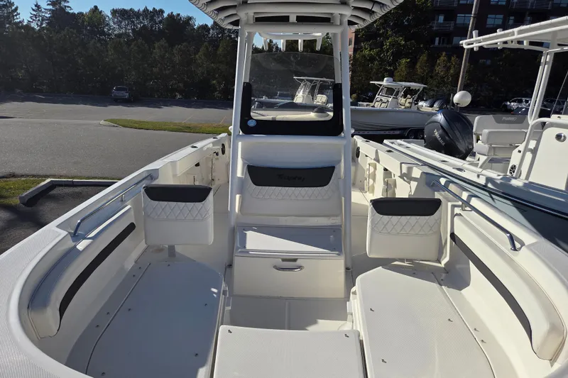 Slide: The Image of 2023 Trophy T24 CC boat interior with seating and console, parked outdoors. - 7