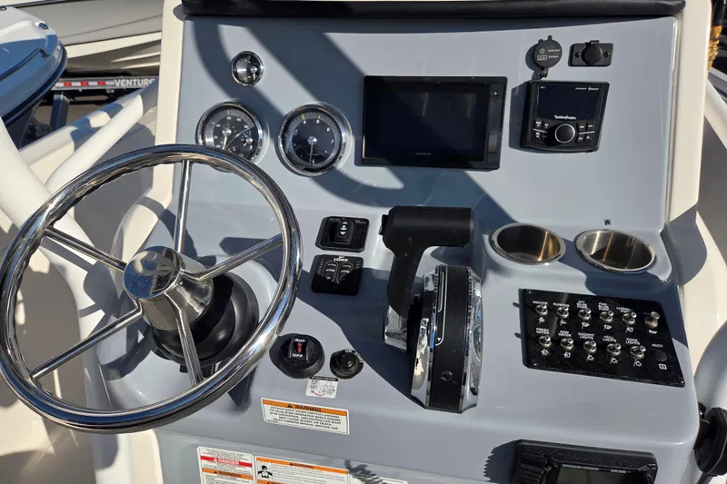 Slide: The Image of 2023 Trophy T24 CC boat dashboard with steering wheel and control panel. - 9