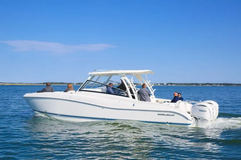 Slide: The Image of 2026 World Cat 325DC boat cruising on a sunny day with passengers onboard. - 1