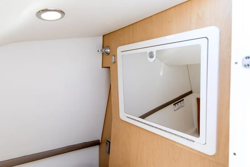 Slide: The Image of Interior cabin of 2026 World Cat 325DC boat with wooden paneling and mirror. - 15