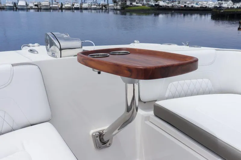 Slide: The Image of Luxury seating area on 2026 World Cat 325DC boat with wooden table and cup holders. - 19