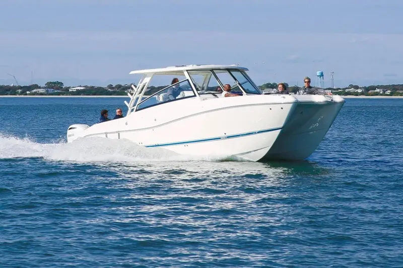 Slide: The Image of 2026 World Cat 325DC cruising on open water with passengers onboard. - 2