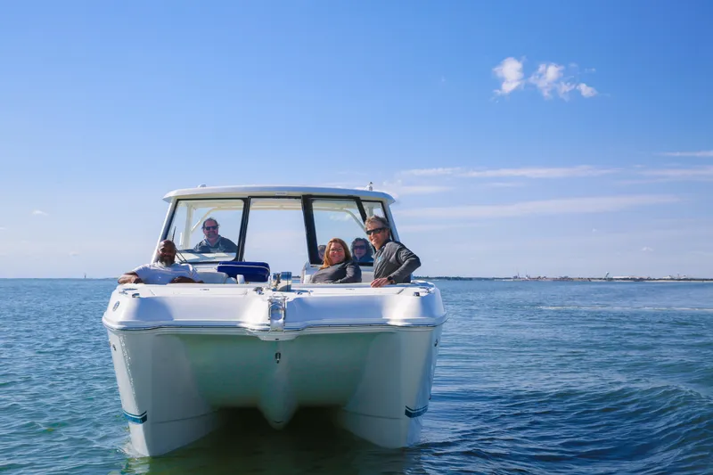 Slide: The Image of 2026 World Cat 325DC boat with passengers on calm sea under clear blue sky. - 5