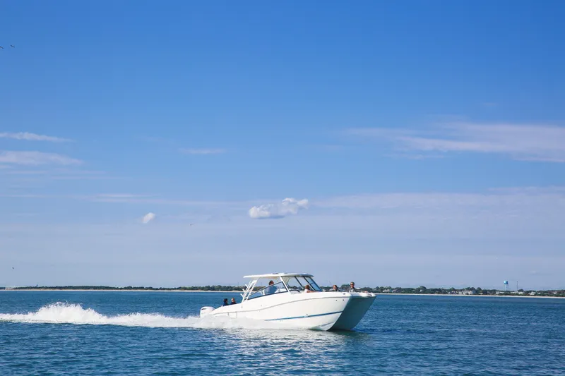 Slide: The Image of 2026 World Cat 325DC cruising on open water under clear blue sky. - 6