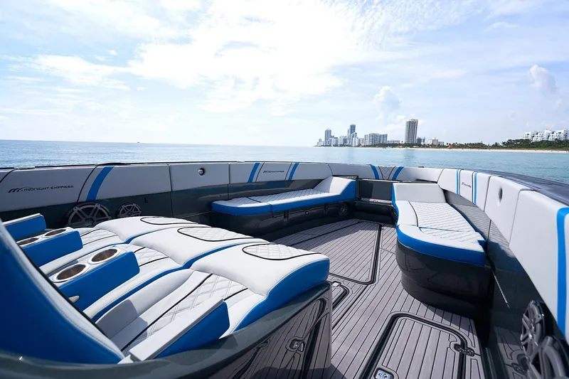 Slide: The Image of 2020 Midnight Express 43' Open boat with luxurious seating, ocean view, and city skyline. - 9