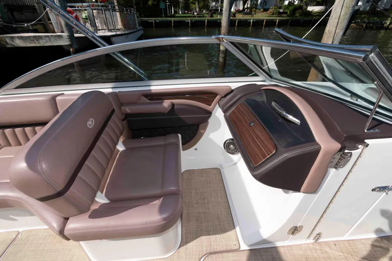 Slide: The Image of 2013 Cobalt A28 boat interior with brown leather seating and sleek dashboard design. - 7