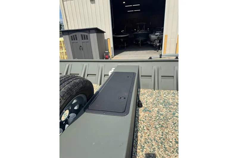 Slide: The Image of 2021 Weldcraft 15 boat with camouflage interior, parked outside a storage facility. - 12