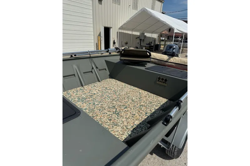 Slide: The Image of 2021 Weldcraft 15 boat interior with camouflage flooring, parked near a building. - 13