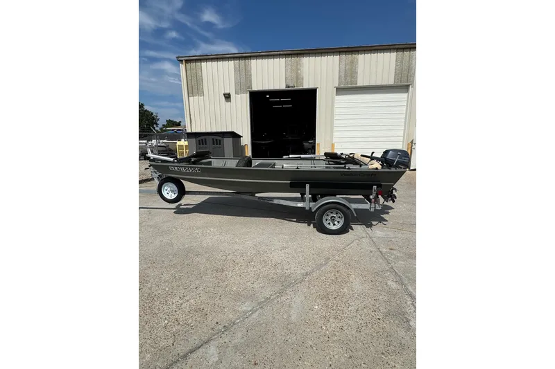 Slide: The Image of 2021 Weldcraft 15 boat on trailer outside a warehouse under clear blue sky. - 6
