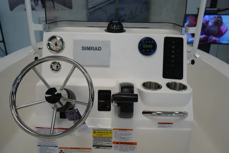 Slide: The Image of 2026 Robalo R160 Center Console dashboard with steering wheel and Simrad display. - 13