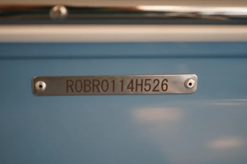 Slide: The Image of 2026 Robalo R160 Center Console boat identification plate on blue surface. - 20