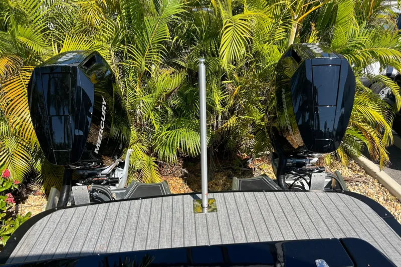 Slide: The Image of 2026 Avalon Excalibur boat with dual Mercury outboard motors, surrounded by lush greenery. - 9