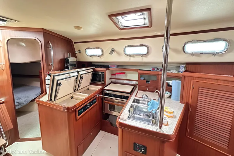 Slide: The Image of Interior of 2010 Island Packet Estero yacht with modern kitchen and wood finish. - 16