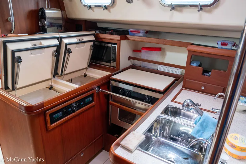 Slide: The Image of 2010 Island Packet Estero yacht kitchen with dual sinks, stove, and storage. - 17