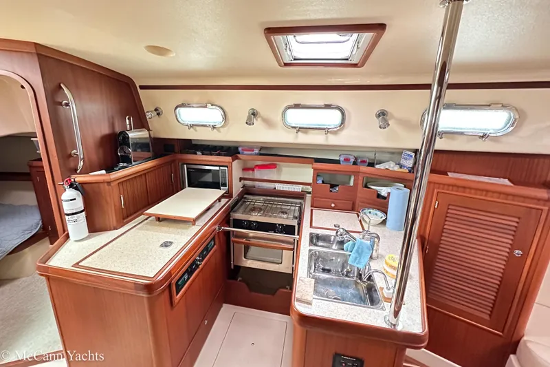 Slide: The Image of 2010 Island Packet Estero yacht interior with modern kitchen and wooden cabinetry. - 18