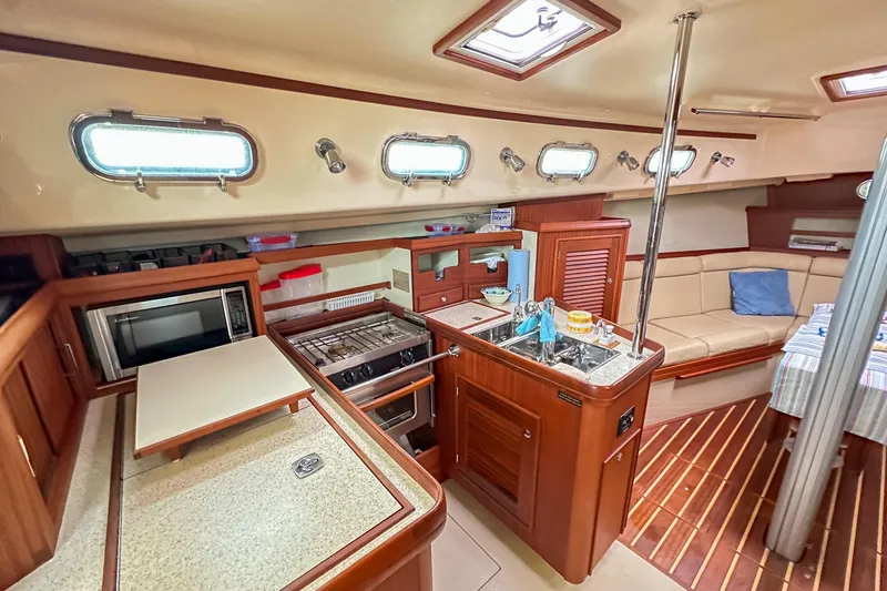 Slide: The Image of 2010 Island Packet Estero yacht interior with kitchen, seating area, and wooden finishes. - 20