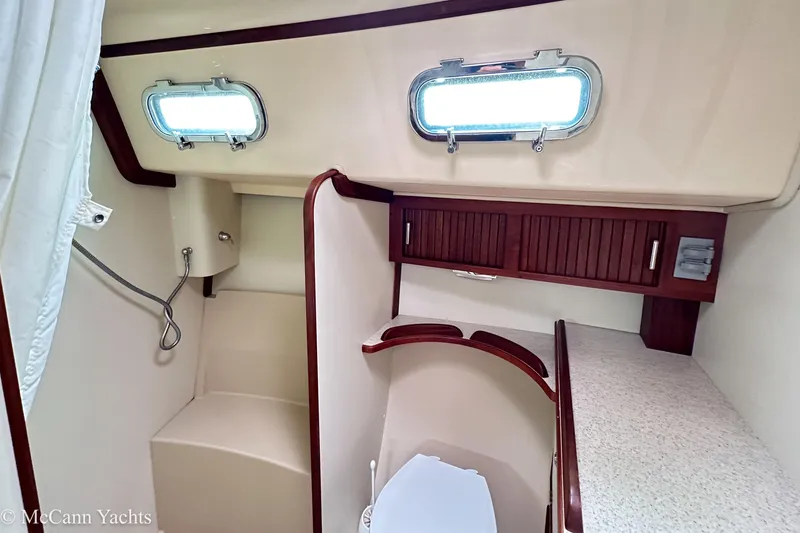 Slide: The Image of 2010 Island Packet Estero yacht bathroom with portholes, shower, and wooden cabinetry. - 23