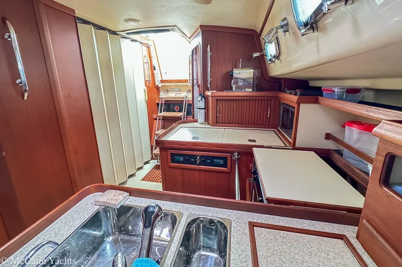 Slide: The Image of 2010 Island Packet Estero yacht interior with wooden cabinetry and modern kitchen amenities. - 25