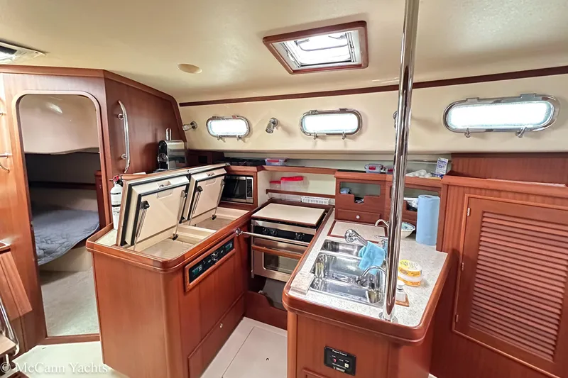 Slide: The Image of 2010 Island Packet Estero yacht interior with modern kitchen and wooden cabinetry. - 30
