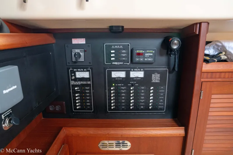 Slide: The Image of Electrical control panel on a 2010 Island Packet Estero yacht, featuring AC and DC switches. - 40