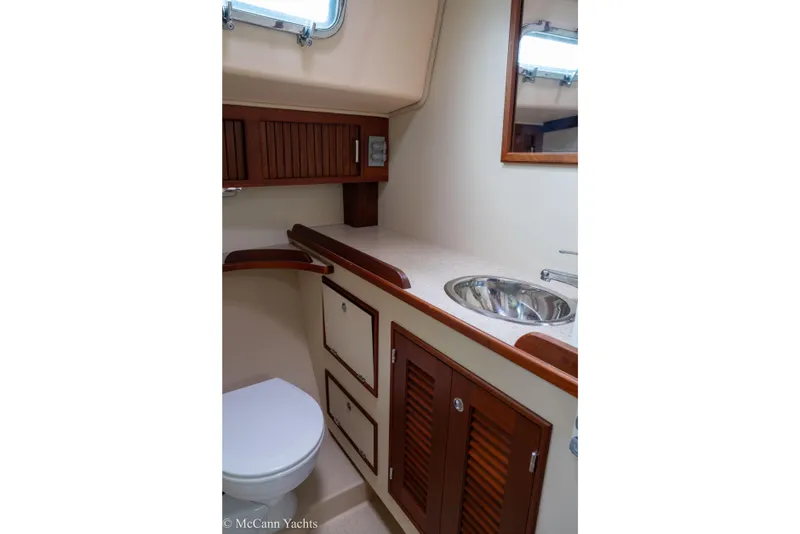 Slide: The Image of 2010 Island Packet Estero yacht bathroom with wooden cabinets and stainless steel sink. - 42