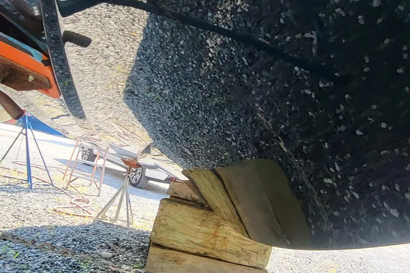 Slide: The Image of 2023 Tigé Z3 boat hull supported by wooden blocks and stands. - 14