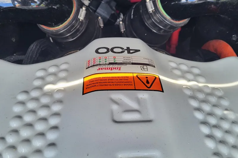 Slide: The Image of Engine cover of 2023 Tigé Z3 boat, featuring Indmar 400 warning label. - 15