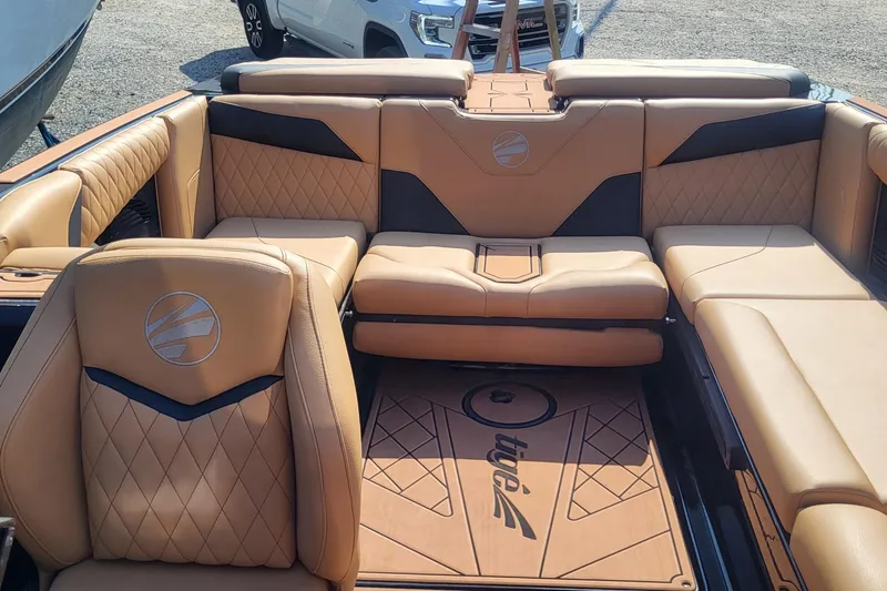 Slide: The Image of 2023 Tigé Z3 boat interior with tan leather seating and logo detailing. - 2