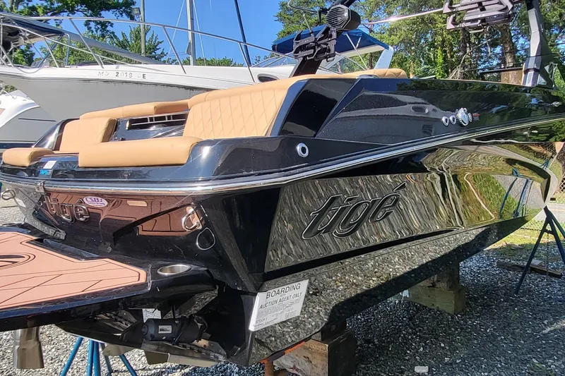 Slide: The Image of 2023 Tigé Z3 boat with sleek black design and tan seating, displayed outdoors. - 8