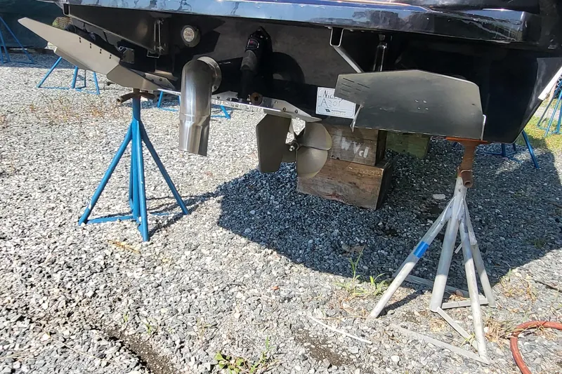 Slide: The Image of 2023 Tigé Z3 boat underside with propeller and supports on gravel. - 9