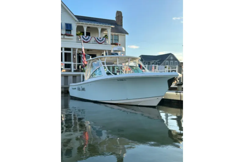 Slide: The Image of 2016 Sailfish 325 DC boat docked near waterfront buildings. - 0